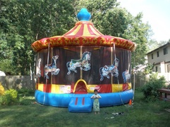 Children playing on a carnival and fair themed inflatable carousel